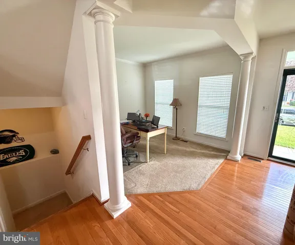a view of a room with wooden floor and furniture