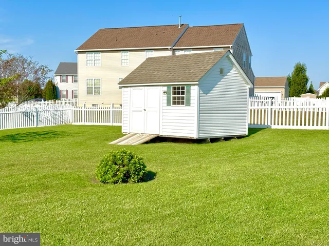 a view of a backyard with a plants and wooden fence