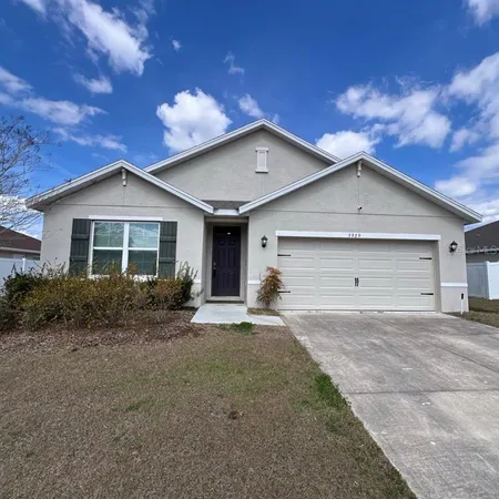 a view of a house with a yard and large tree