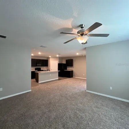 an empty room with a ceiling fan and a window