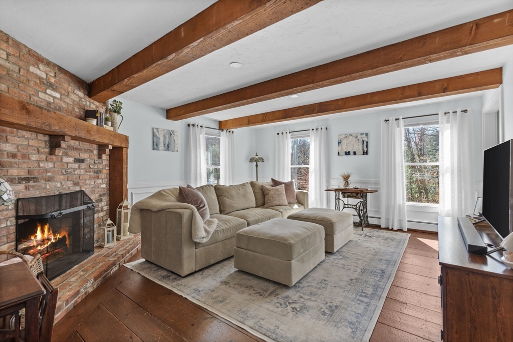 57 Whitewood Road Milford, MA 01757 - Photo 11 of 40 a living room with furniture a flat screen tv and a fireplace