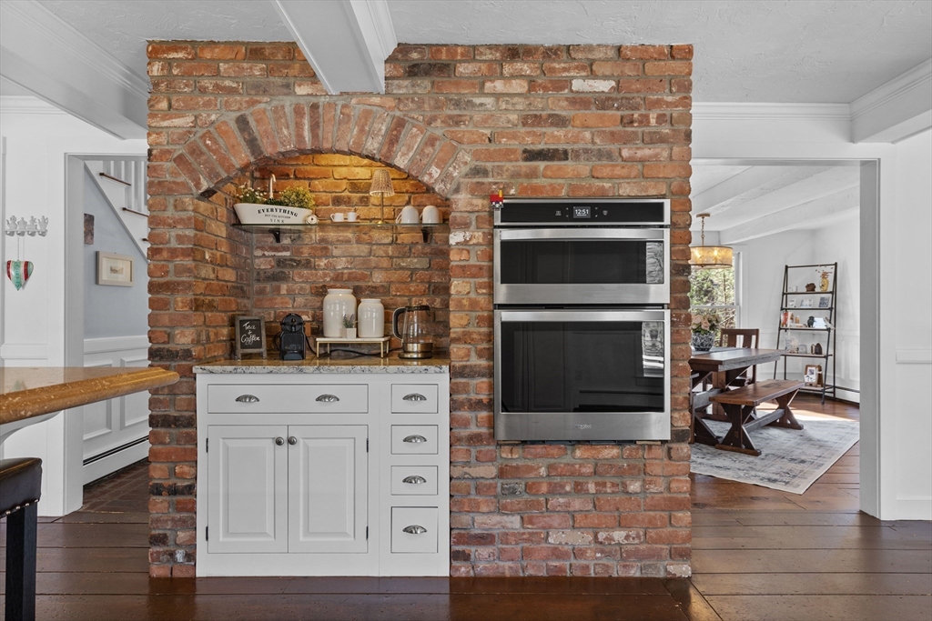 57 Whitewood Road Milford, MA 01757 - Photo 6 of 40 a kitchen with granite countertop a stove and a fireplace