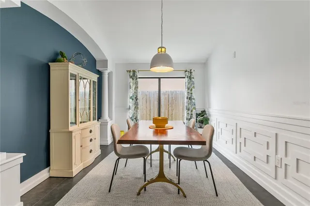 a dining room with furniture a chandelier and wooden floor