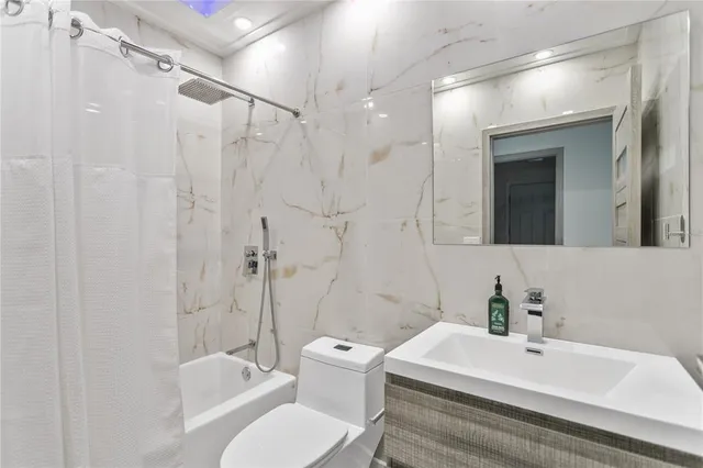 a bathroom with a white bath tub a sink and mirror