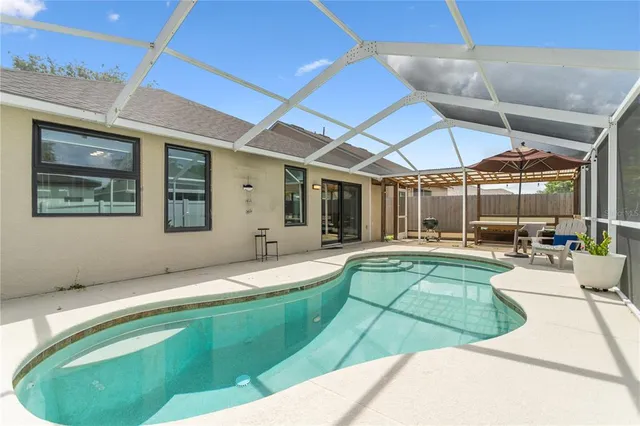 a swimming pool with outdoor seating and yard