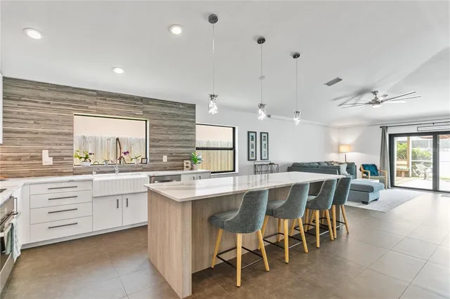 a large kitchen with kitchen island a sink table and chairs