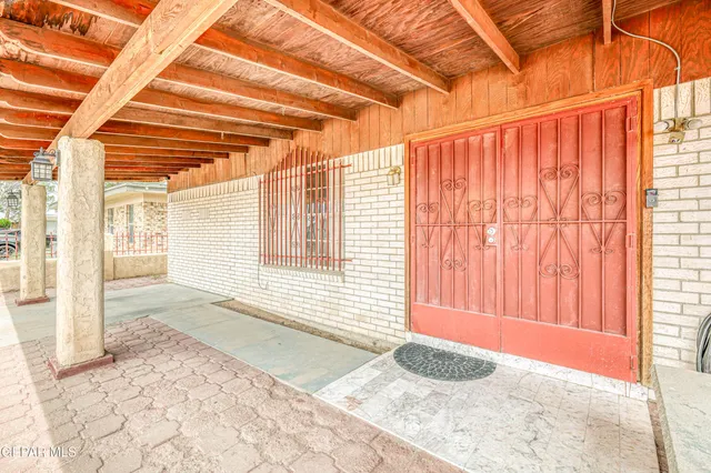 a view of an empty room with chandelier fan and a window