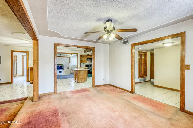 a view of a livingroom with a fireplace a ceiling fan and carpet