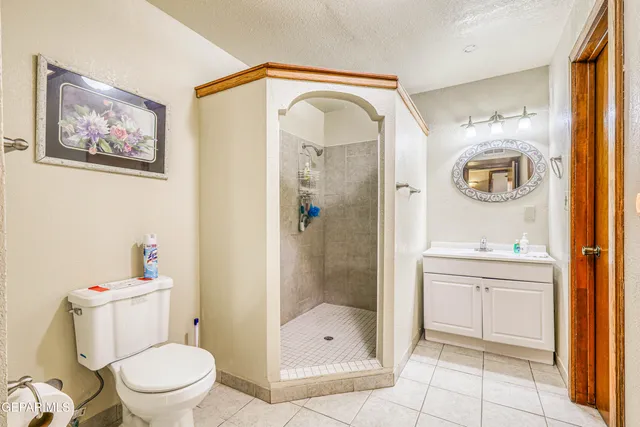 a view of an empty room with chandelier fan and fire place