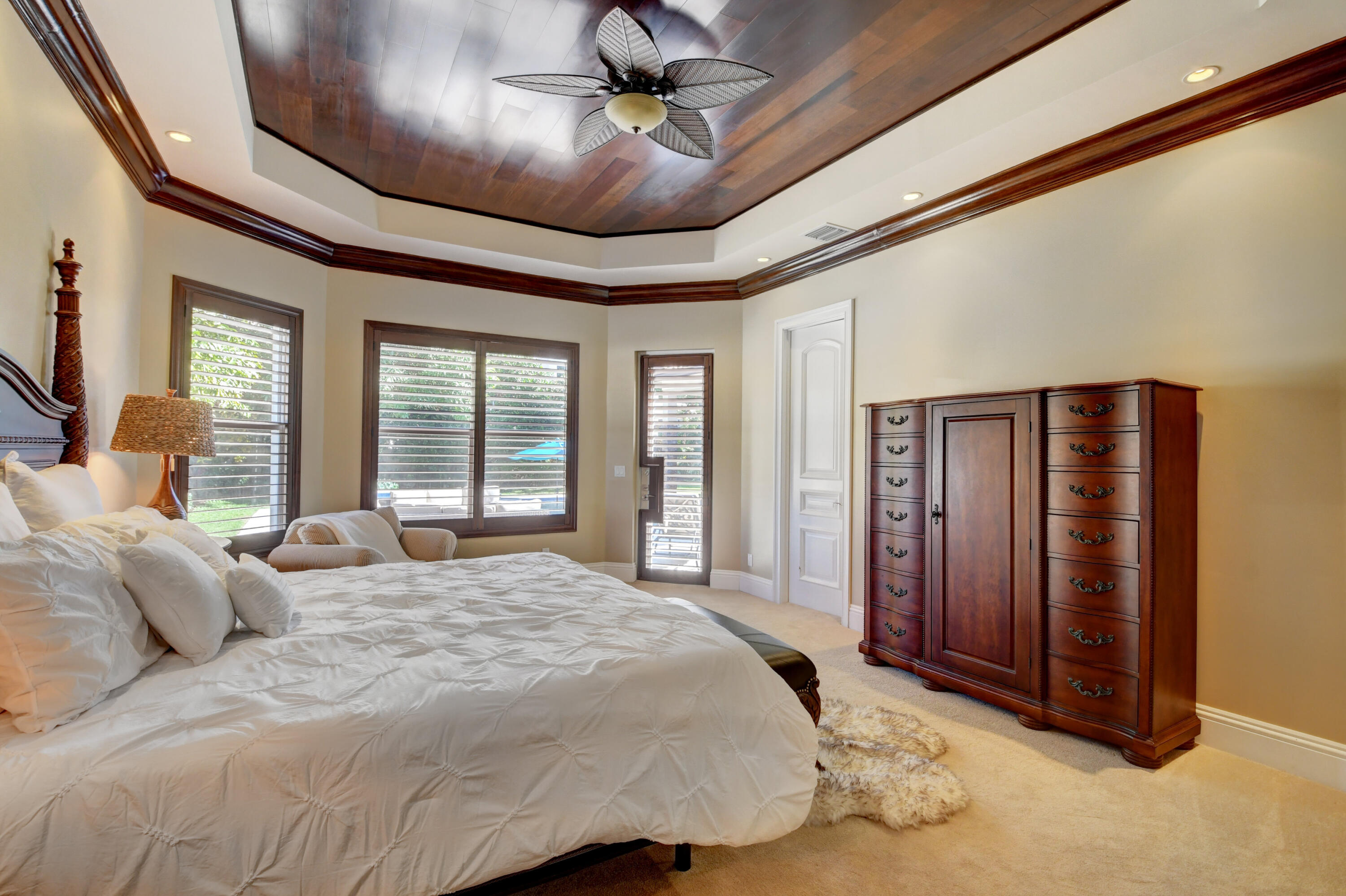 1130 Spanish River Road Boca Raton, FL 33432 - Photo 43 of 59 a bedroom with a large bed chandelier and a large window