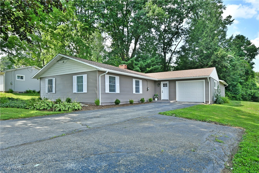 7655 Connelly Road Masury, OH 44438 - Photo 6 of 46 Single story home featuring a garage, driveway, a front lawn, and a chimney