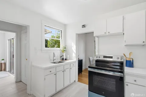 a kitchen with sink stove and cabinets