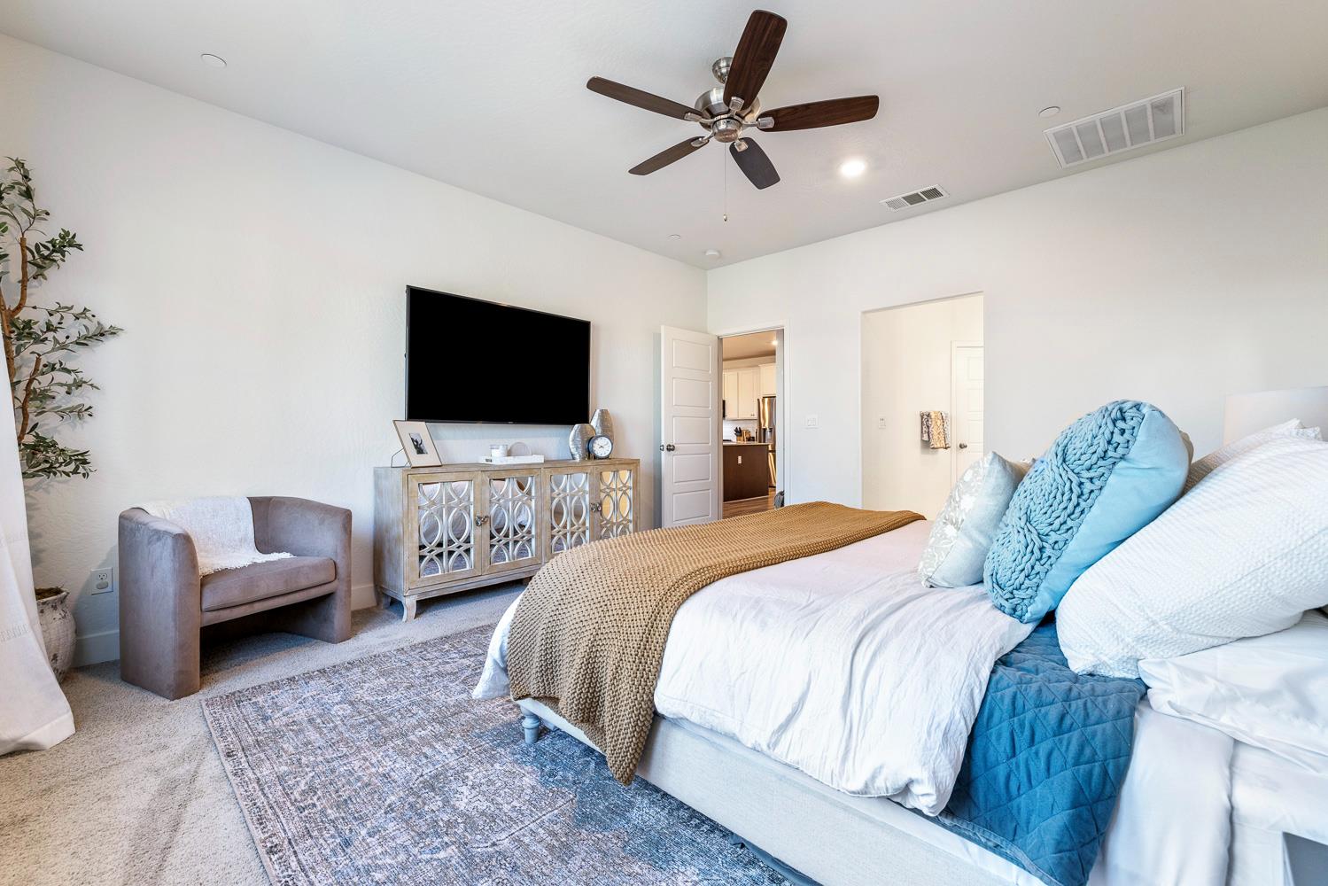 601 Wishon Avenue Madera, CA 93636 - Photo 19 of 33 a spacious bedroom with a bed a couch and a flat screen tv