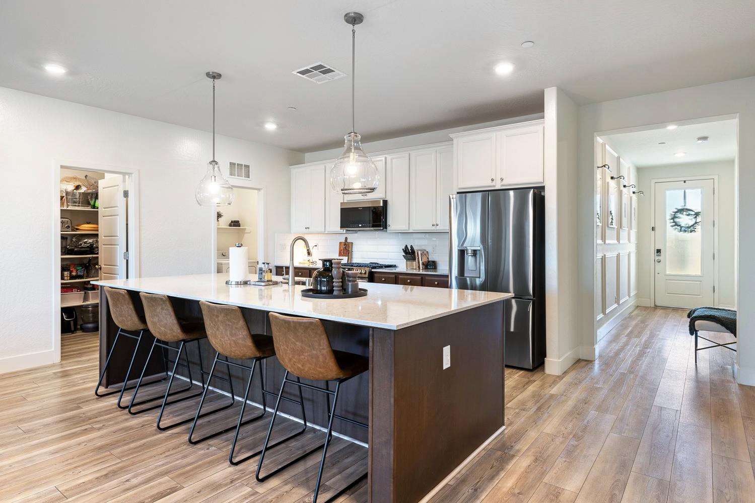 601 Wishon Avenue Madera, CA 93636 - Photo 10 of 33 a kitchen with stainless steel appliances a dining table chairs refrigerator and sink