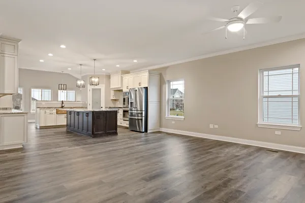 a big room with wooden floors and kitchen view