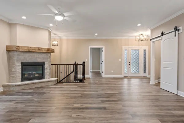 a view of an empty room with wooden floor and a fireplace