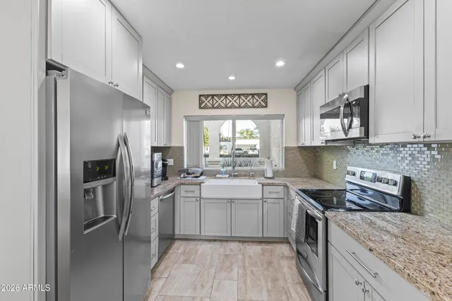 a kitchen with stainless steel appliances granite countertop a refrigerator and a sink