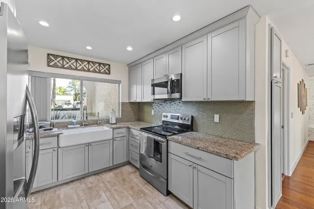 a kitchen with stainless steel appliances granite countertop a sink stove and refrigerator