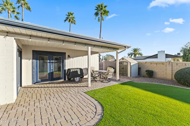 a view of a swimming pool with a patio and a yard