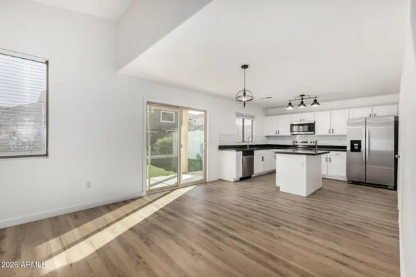 a kitchen with stainless steel appliances kitchen island granite countertop a refrigerator a stove and a sink with granite countertops