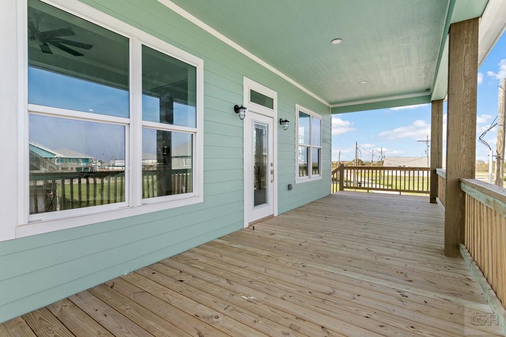 971 Tidelands Crystal Beach, TX 77650 - Photo 14 of 38 a view of a porch with wooden floor and floor to ceiling window