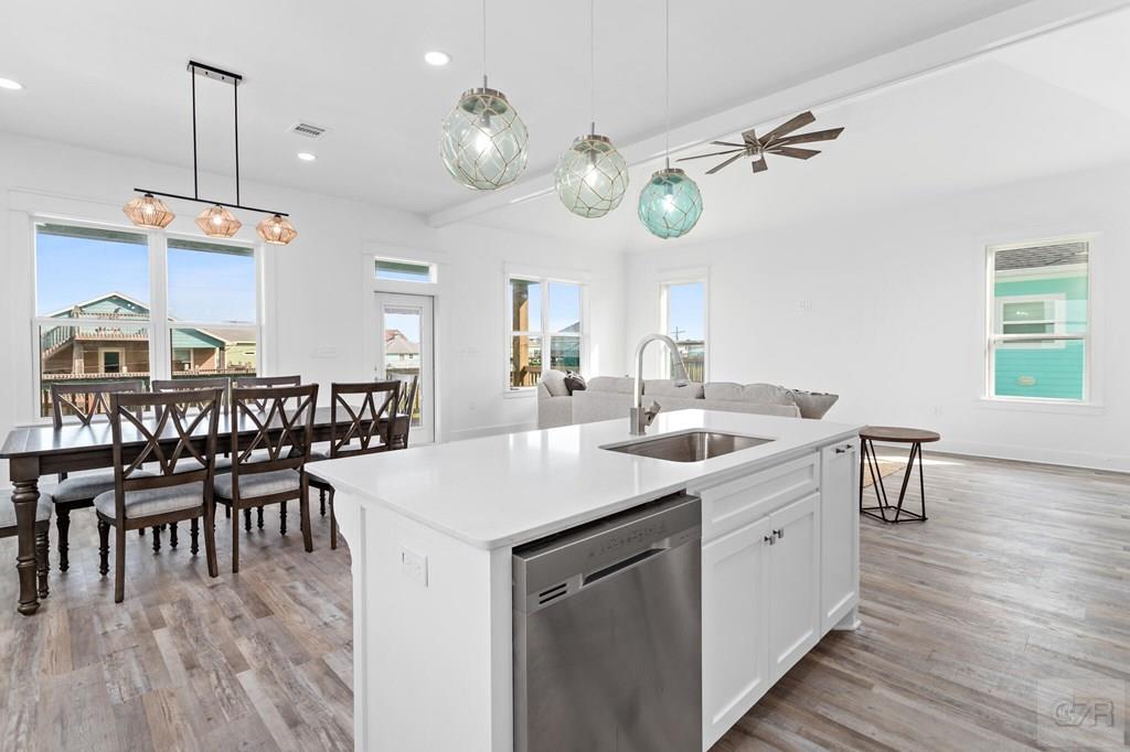 971 Tidelands Crystal Beach, TX 77650 - Photo 26 of 38 a kitchen with a dining table chairs cabinets and stainless steel appliances