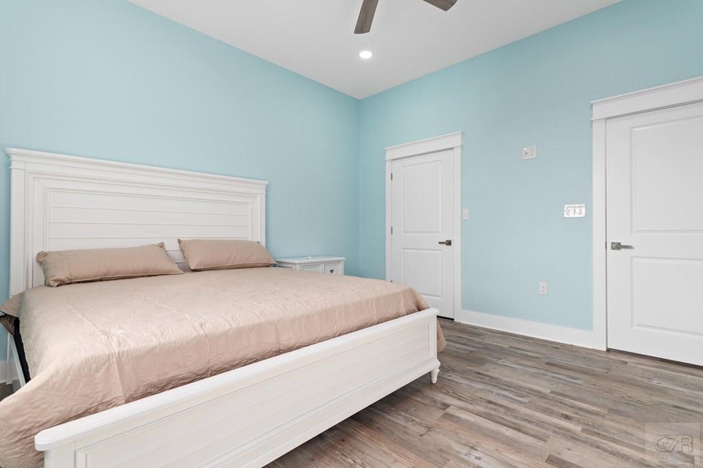 971 Tidelands Crystal Beach, TX 77650 - Photo 28 of 38 a bedroom with a bed and wooden floor