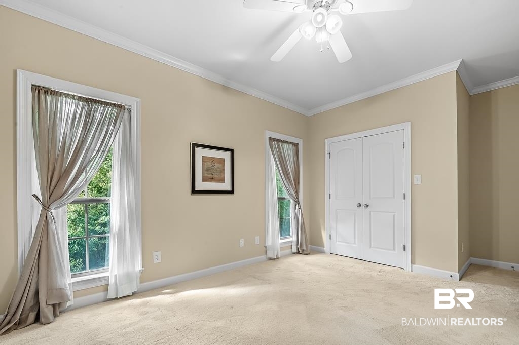 29976 Dolive Ridge Daphne, AL 36527 - Photo 43 of 58 Unfurnished bedroom featuring ornamental molding, a closet, light colored carpet, and ceiling fan