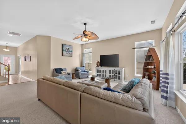 a living room with furniture kitchen view and a chandelier
