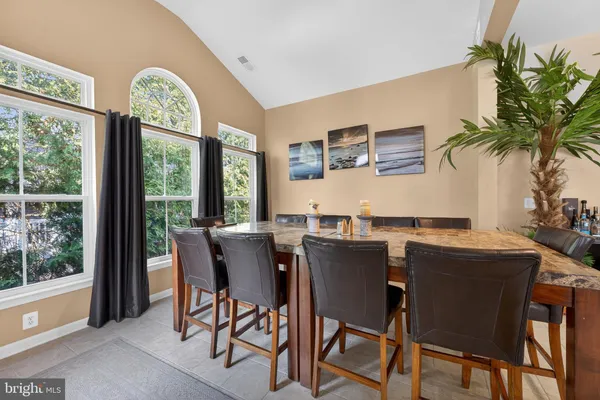 a dining room with stainless steel appliances granite countertop a table and chairs