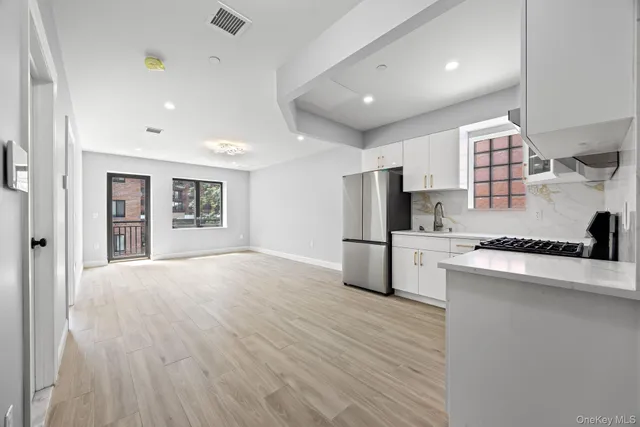 a kitchen with stainless steel appliances a refrigerator and a stove top oven