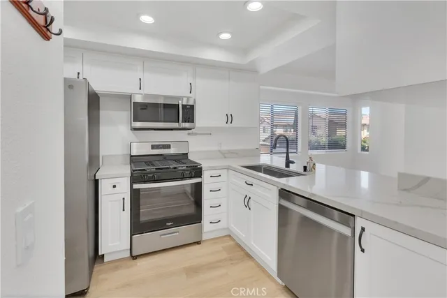 a kitchen with stainless steel appliances a stove sink and microwave