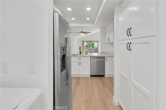 a view of a kitchen with a white cabinets and wooden floor