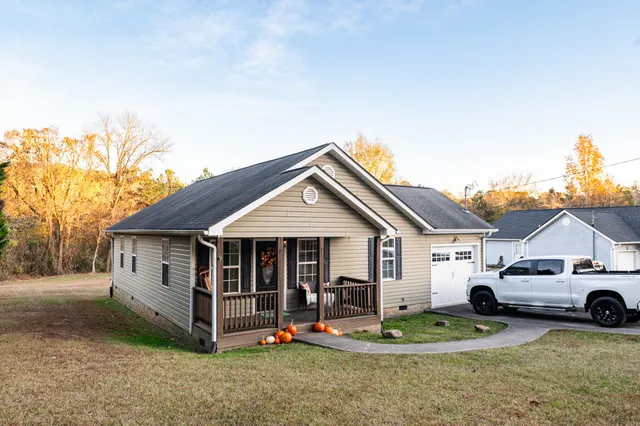 a white house covered with tall trees