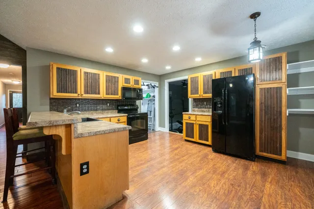 a kitchen with stainless steel appliances granite countertop a refrigerator and a stove top oven