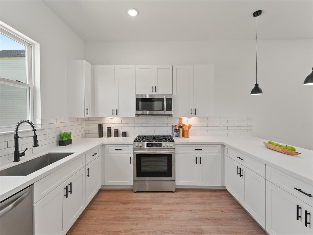 a white kitchen with sink and white stainless steel appliances
