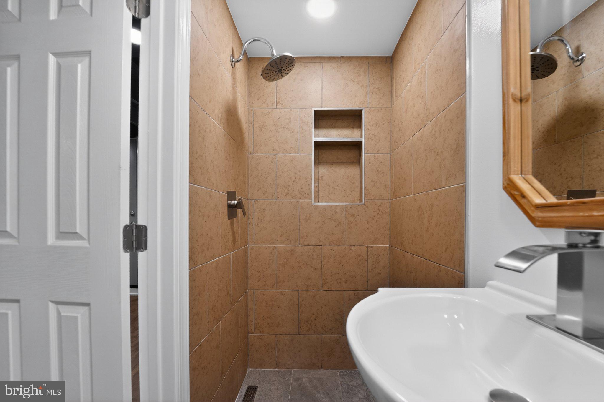 643 South Wickham Road Baltimore, MD 21229 - Photo 17 of 32 Sleek, modern shower with warm tones.