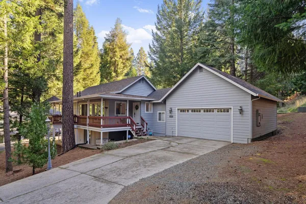 a front view of a house with yard and trees