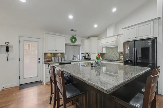 a kitchen with granite countertop kitchen island a table and chairs in it