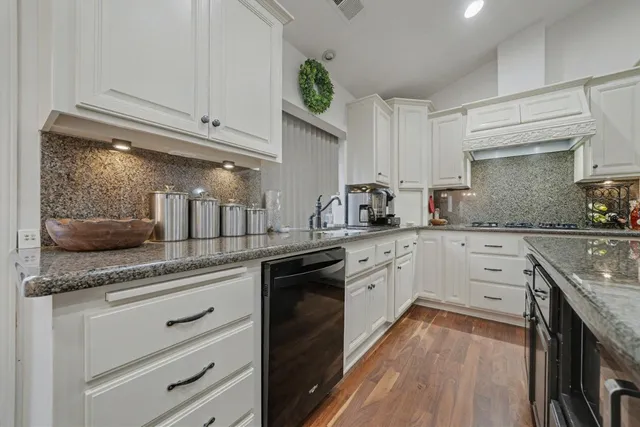 a kitchen with granite countertop cabinets stainless steel appliances and a counter space