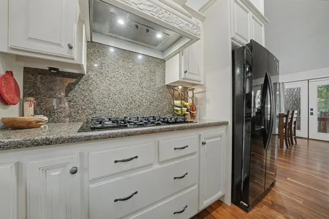 a kitchen with granite countertop white cabinets and white appliances