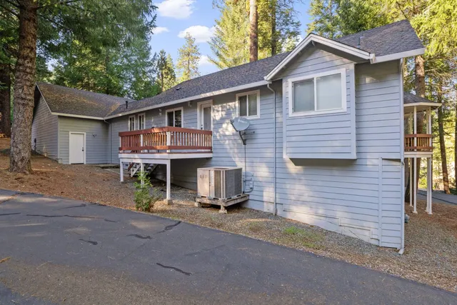 a view of a house with a yard and large tree
