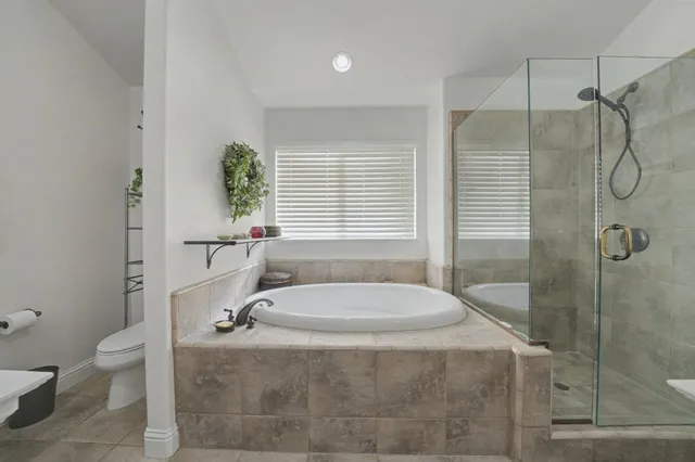 a bathroom with a granite countertop sink a toilet and shower