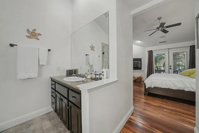 a en suite bathroom with a granite countertop sink and a mirror