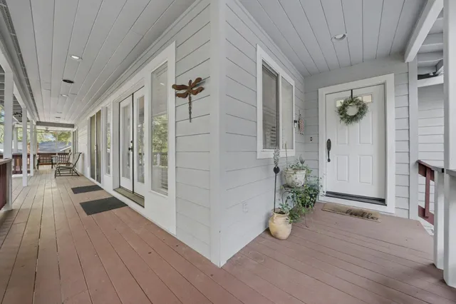 a view of a hallway with wooden floor and a living room