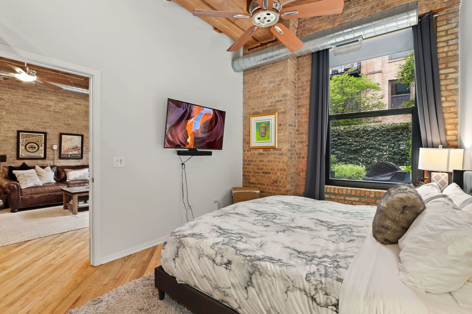 1040 West Adams Street, Unit 224 Chicago, IL 60607 - Photo 13 of 32 a bedroom with a bed and a flat screen tv