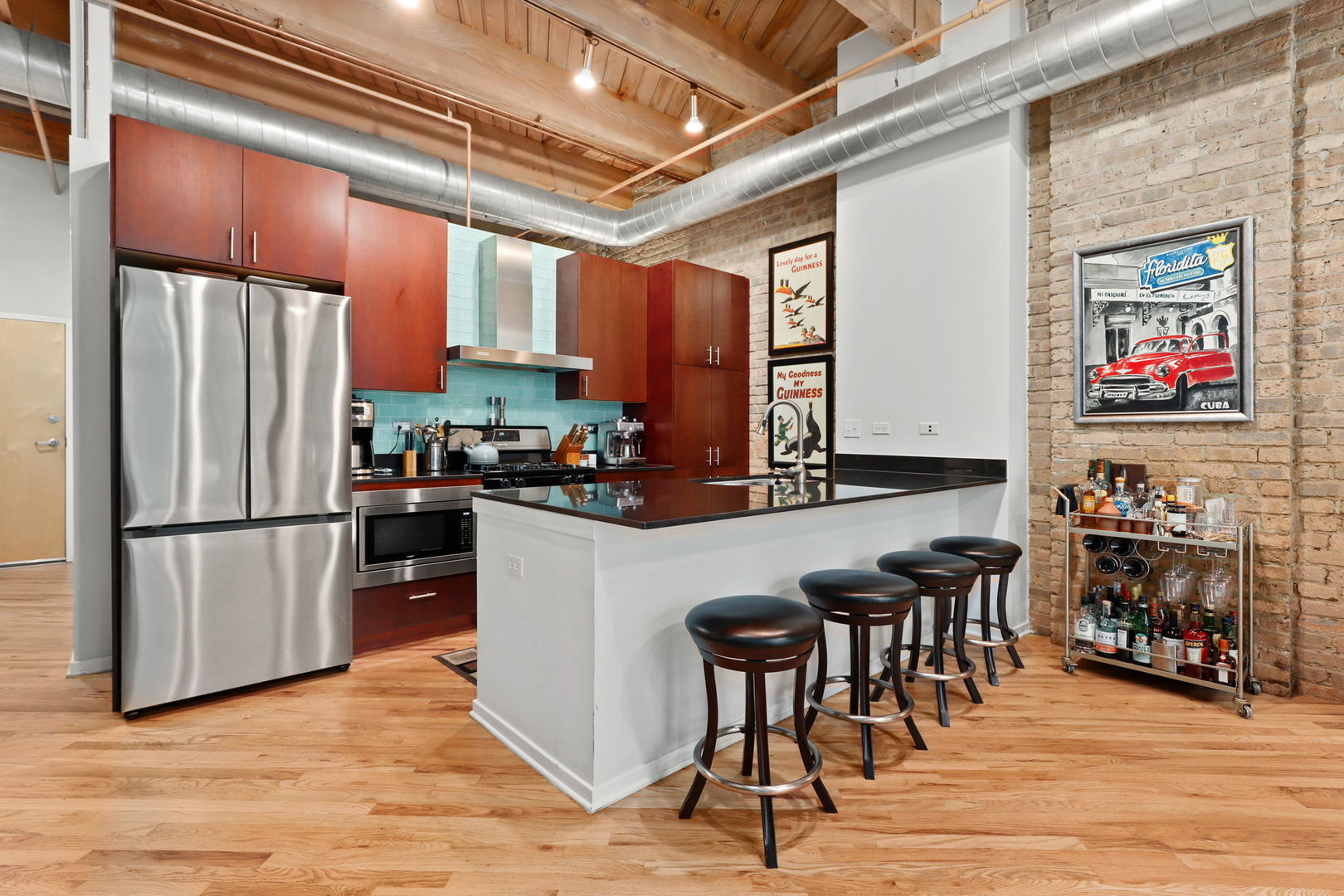 1040 West Adams Street, Unit 224 Chicago, IL 60607 - Photo 10 of 32 a kitchen with stainless steel appliances granite countertop a refrigerator a stove a sink and a dining table with wooden floor