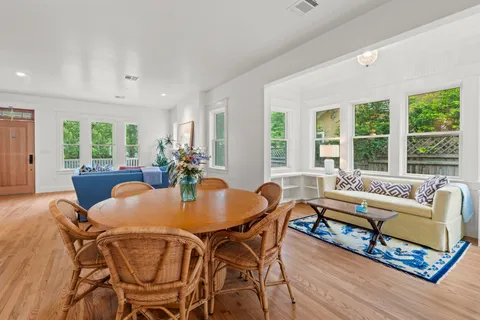 a view of a dining room with furniture large windows and wooden floor