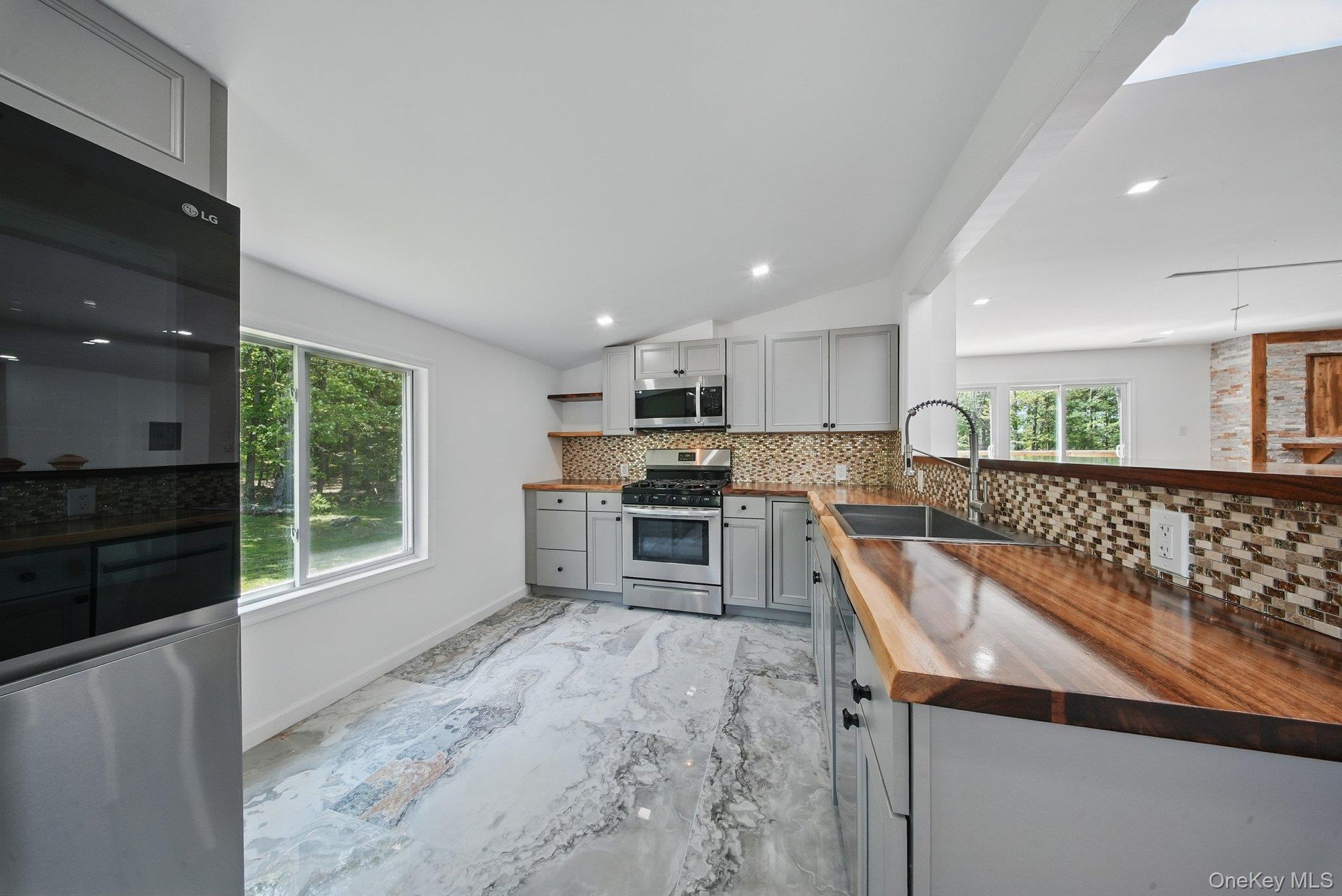 206 High Road Glen Spey, NY 12737 - Photo 25 of 42 a kitchen with stainless steel appliances granite countertop a stove a sink and a microwave