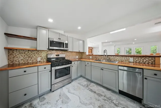 a kitchen with granite countertop cabinets stainless steel appliances and a counter space